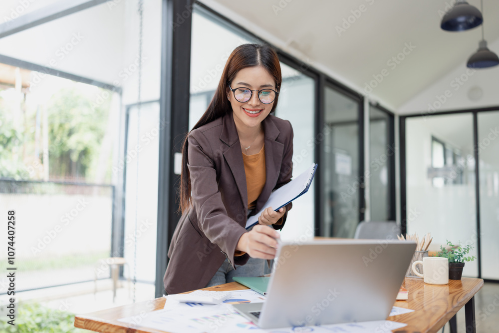 Asian businesswoman working on laptop with finances analysis report at desk in office, business financing, accounting banking, Asian businesswoman working on laptop with finances analysis report at desk in office, business financing, accounting banking,