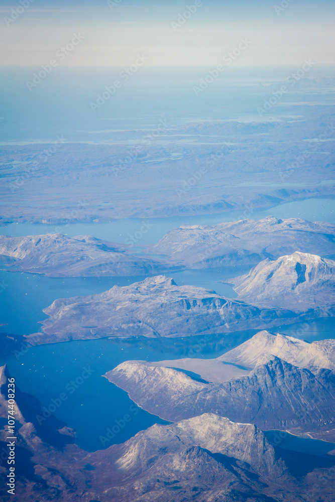 Fototapeta premium Greenlandic ice cap with frozen mountains and fjord aerial view