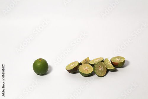 Green lime fruits on isolated white background. Sliced and unsliced. photo