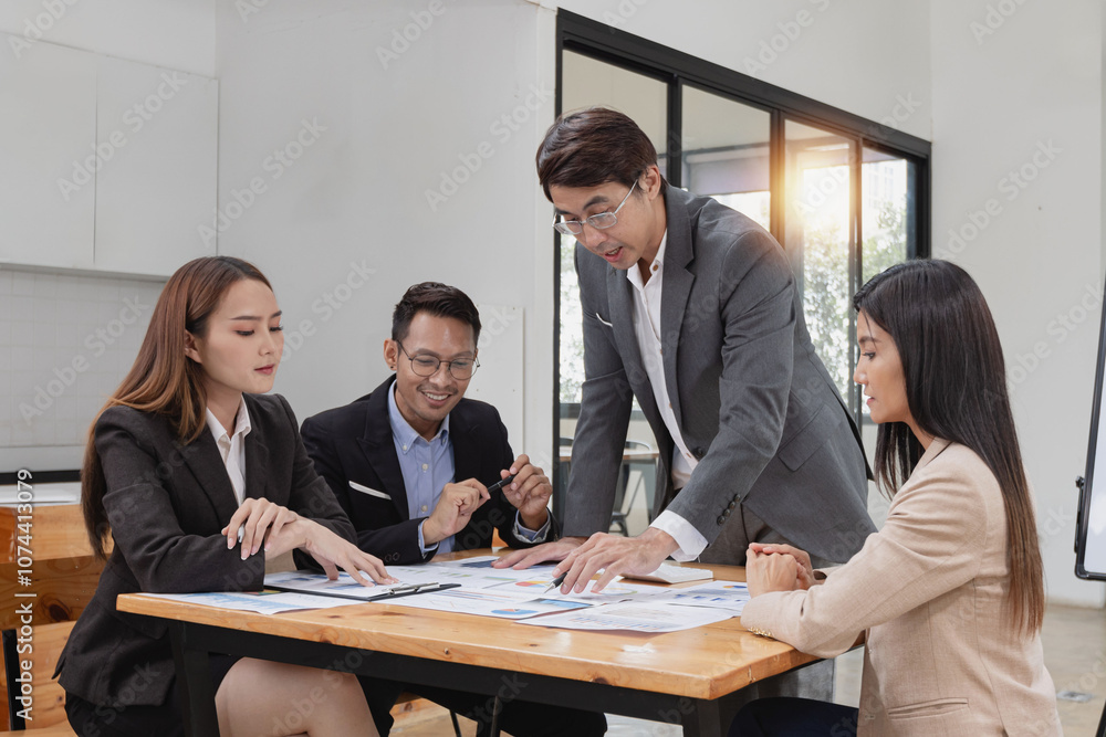Asian business teamwork working with analysis report and advisor showing plan, Financial analysis and Marketing teamwork concept. Asian business teamwork working with analysis report and advisor showing plan, Financial analysis and Marketing teamwork concept.