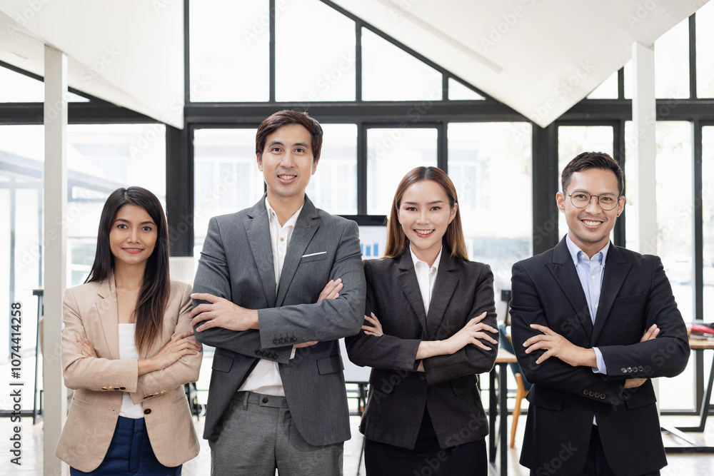 Confident team of Asian business people stands at office. Confident team of Asian business people stands at office.