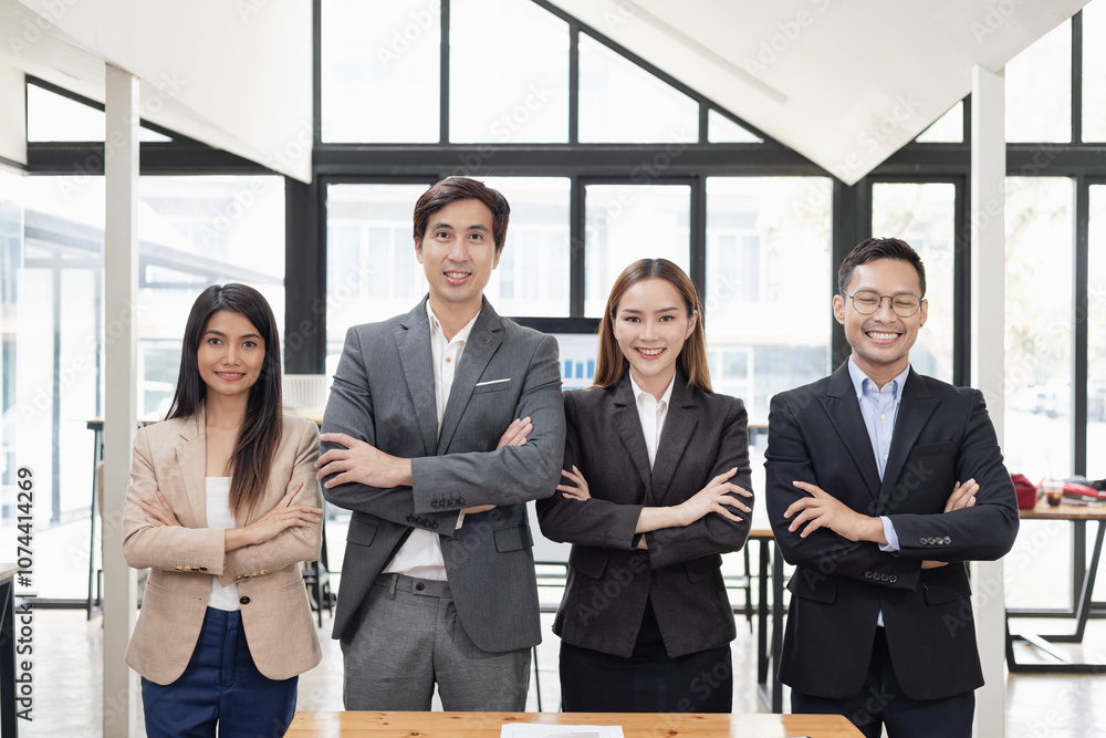 Confident team of Asian business people stands at office. Confident team of Asian business people stands at office.