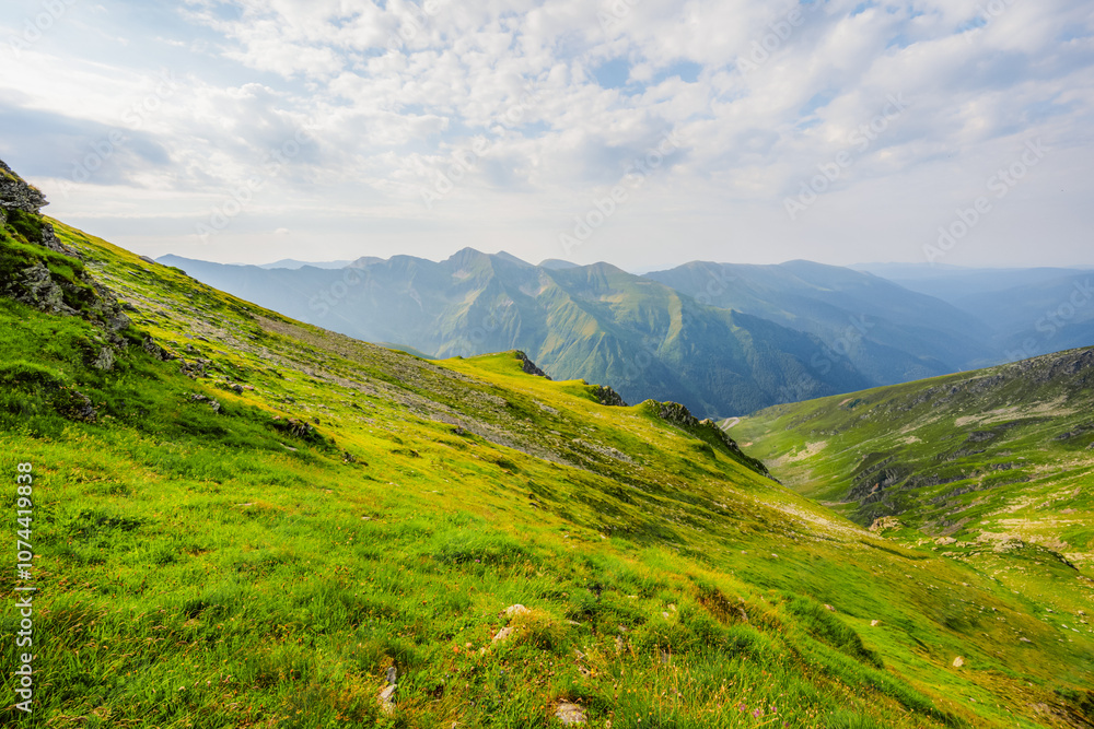 Hiking in Fagaras mountains on Iezerul Caprei peak over Transfagarasan serpentine road carpathian mountains. Mountains landscape Hiking in Fagaras mountains on Iezerul Caprei peak over Transfagarasan serpentine road carpathian mountains. Mountains landscape
