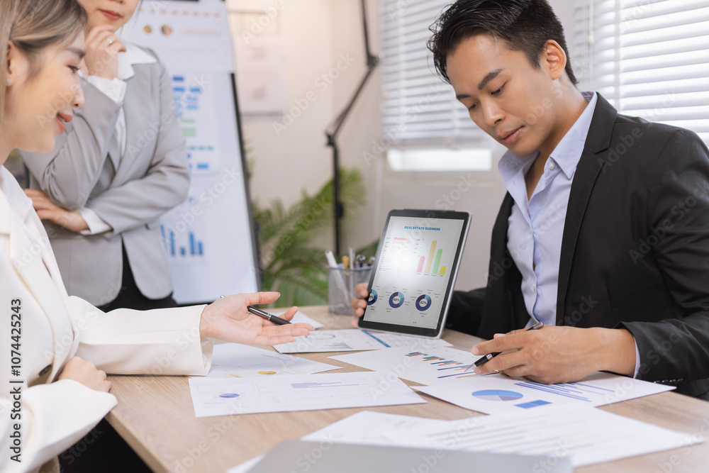 Asian business teamwork working on digital tablet with analysis report and advisor showing plan, Financial analysis and Marketing teamwork concept. Asian business teamwork working on digital tablet with analysis report and advisor showing plan, Financial analysis and Marketing teamwork concept.