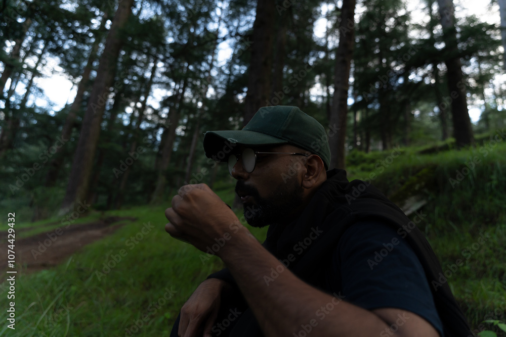 Close up shot of young Indian man holding coffee, taking break during hiking. Male hiker taking rest outdoors. Close up shot of young Indian man holding coffee, taking break during hiking. Male hiker taking rest outdoors.