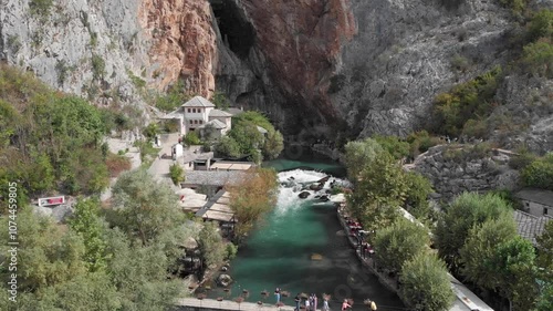 Aerial: Blagaj in Bosnia and Hercegovina. Flying towards the cliff photo