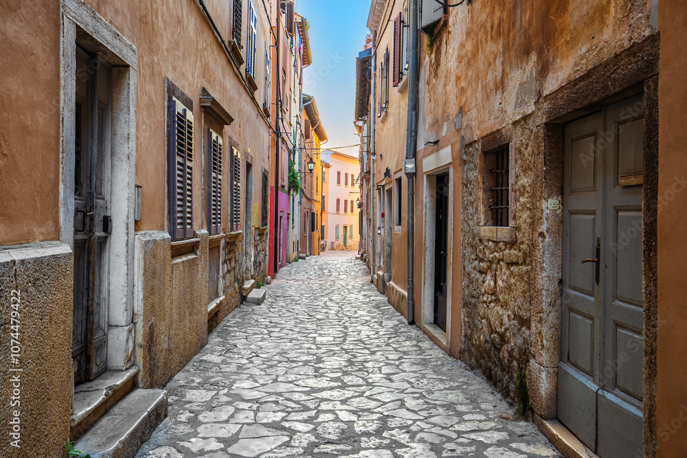 Rovinj, Croatia - Empty narrow street at the Old Town of Rovinj in a sunny summer morning with traditional cobblestones, colorful houses, windows and doors
