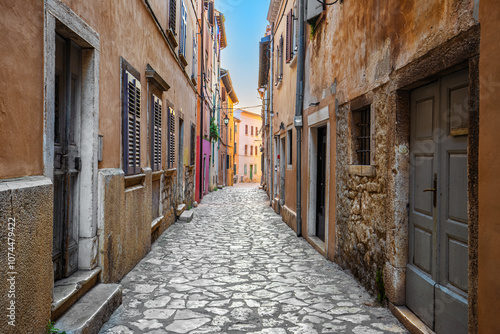 Obraz na płótnie Rovinj, Croatia - Empty narrow street at the Old Town of Rovinj in a sunny summer morning with traditional cobblestones, colorful houses, windows and doors w salonie
