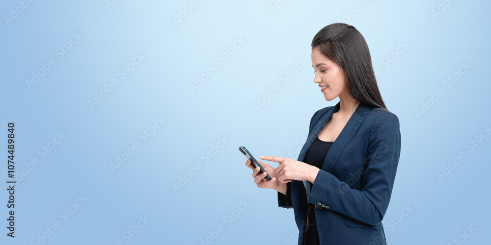 Smiling woman in business attire using a smartphone, standing ag Smiling woman in business attire using a smartphone, standing ag