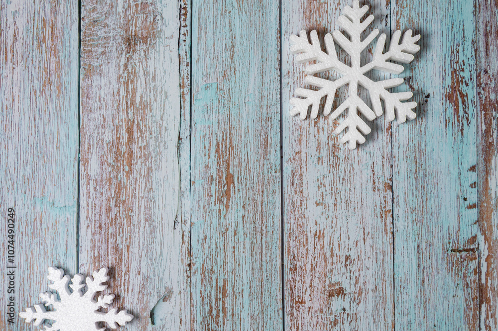 Fototapeta premium White decorative snowflakes on blue wooden background, copy space