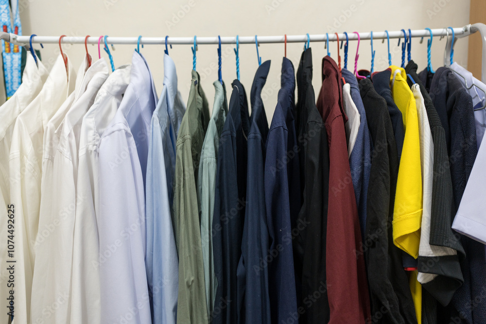 Collection of clothes hanging on rack at home Collection of clothes hanging on rack at home