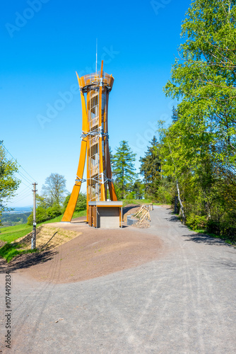 The Hamstejn lookout tower stands tall with its spiral staircase and steel structure, surrounded by lush greenery in Bohemian Paradise, Czechia, inviting visitors to enjoy scenic views.