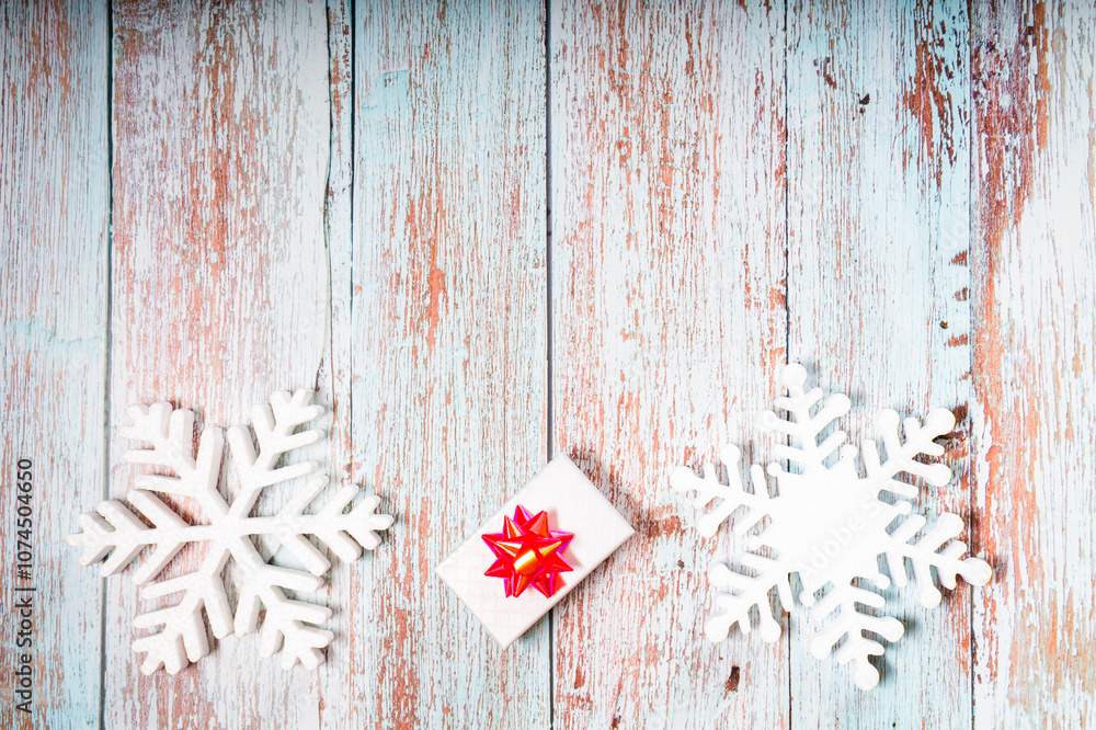 White decorative snowflakes and giftbox on a wooden background, copy space