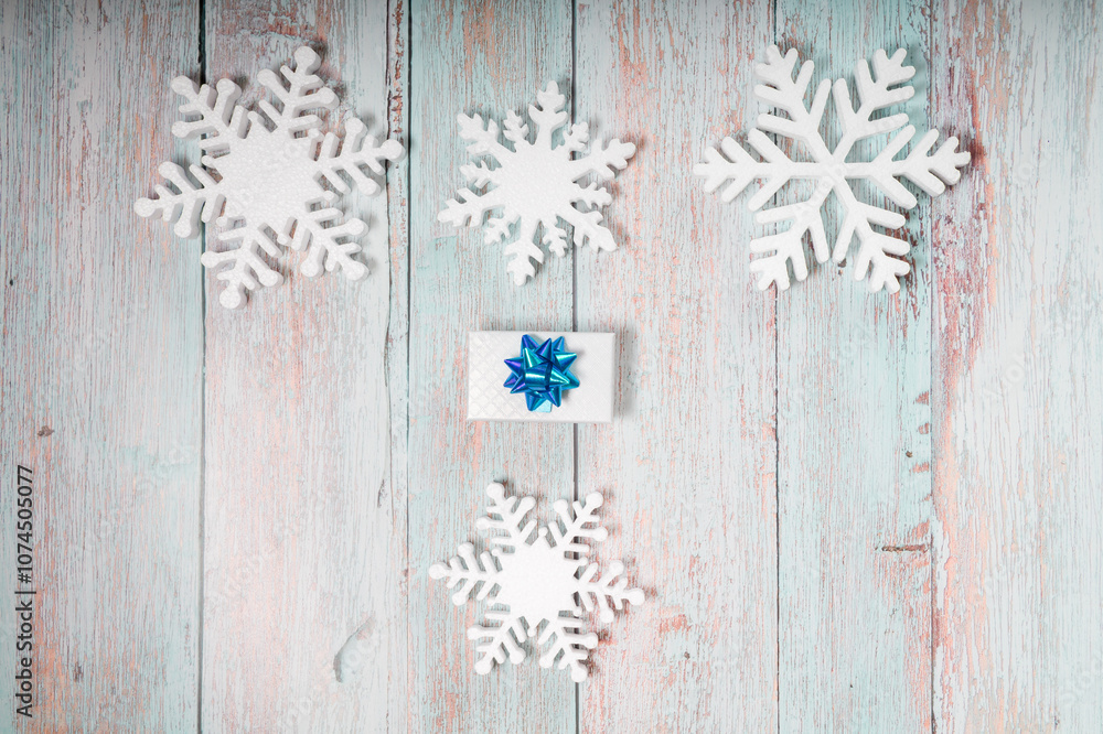 White decorative snowflakes and giftbox on a wooden background, copy space White decorative snowflakes and giftbox on a wooden background, copy space