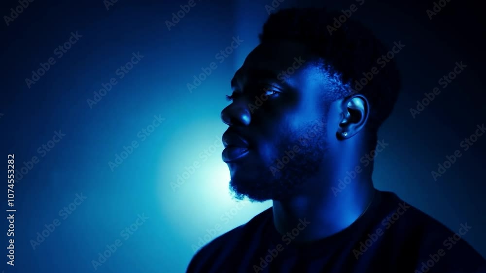 Young man showcasing dynamic poses under striking blue studio lights Young man showcasing dynamic poses under striking blue studio lights