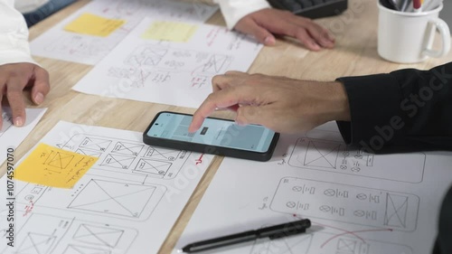 UX UI designers discussing and brainstorming on wireframes for a website and mobile app prototype, in the concept of website and mobile application design concept.