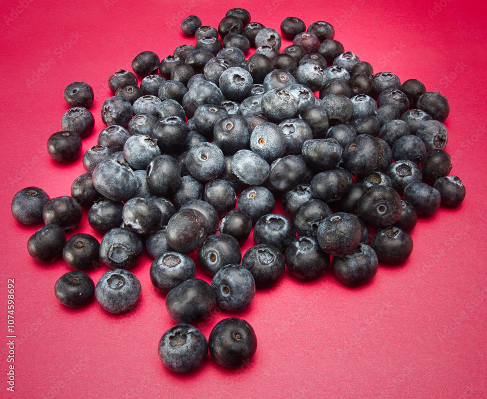 A pile of blueberries isolated on red background A pile of blueberries isolated on red background