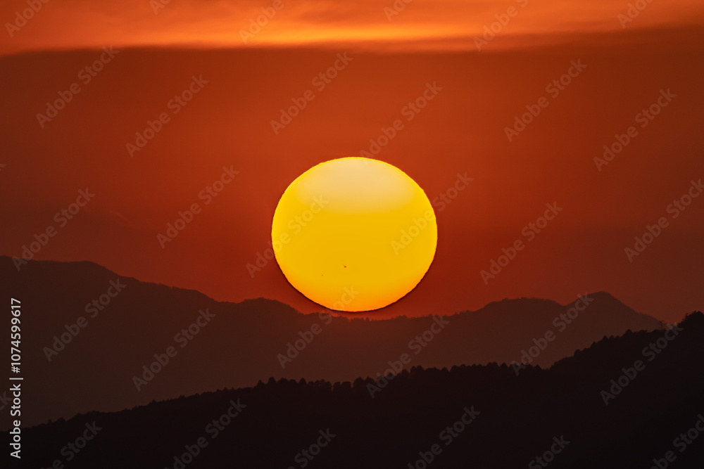 夕焼けの中、山に沈む太陽 夕焼けの中、山に沈む太陽