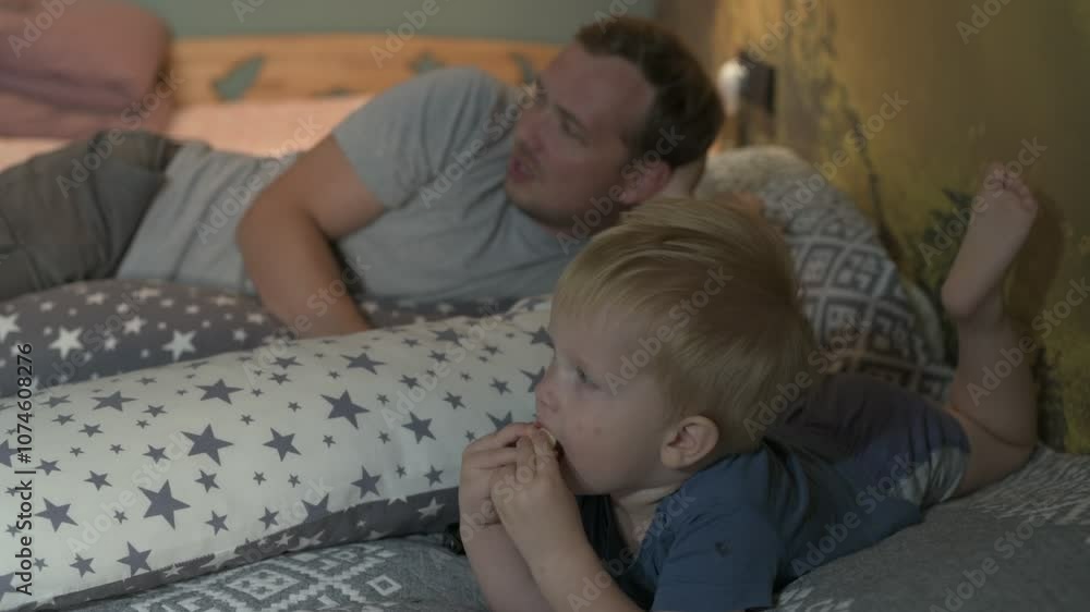 Happy family father and little son spending time together at home, playing games and watching cartoons Happy family father and little son spending time together at home, playing games and watching cartoons