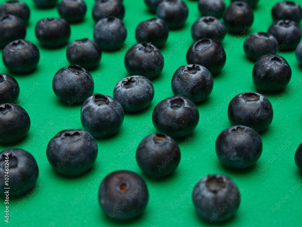 Individual blueberries on a green background are spaced apart in lines Individual blueberries on a green background are spaced apart in lines