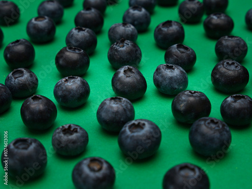 Individual blueberries on a green background are spaced apart in lines