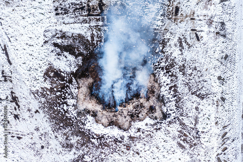 Burning manure pile at farm, air pollution and contamination, aerial shot from drone pov photo