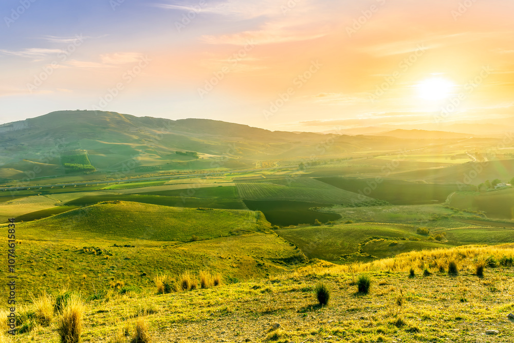 Obraz premium beautiful landscape in a yellow golden field in autumn or summer evening with nice rustic view of hills in countryside