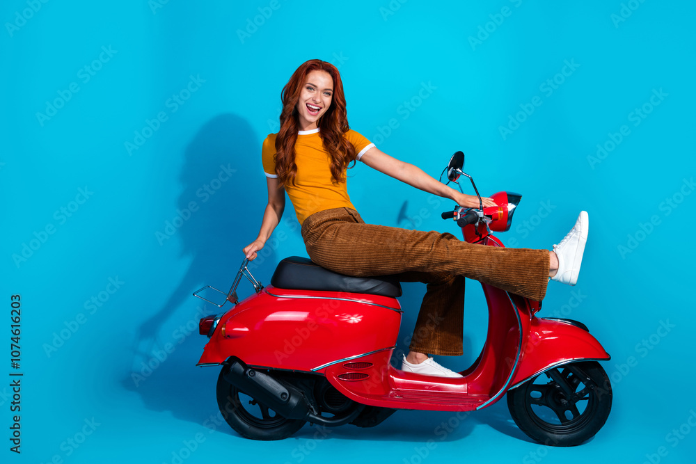 Photo of adorable cute positive woman wear trendy clothes drive moped isolated on blue color background Photo of adorable cute positive woman wear trendy clothes drive moped isolated on blue color background