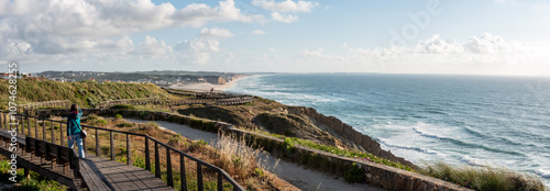 A young woman walking on a boardwalk at the Portuguese coast near Foz do Arelho
