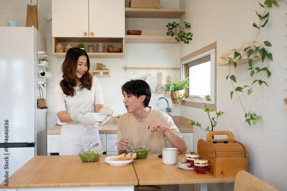 Beautiful asian wife serving freshly baked dish to husband with a smile. Beautiful asian wife serving freshly baked dish to husband with a smile.