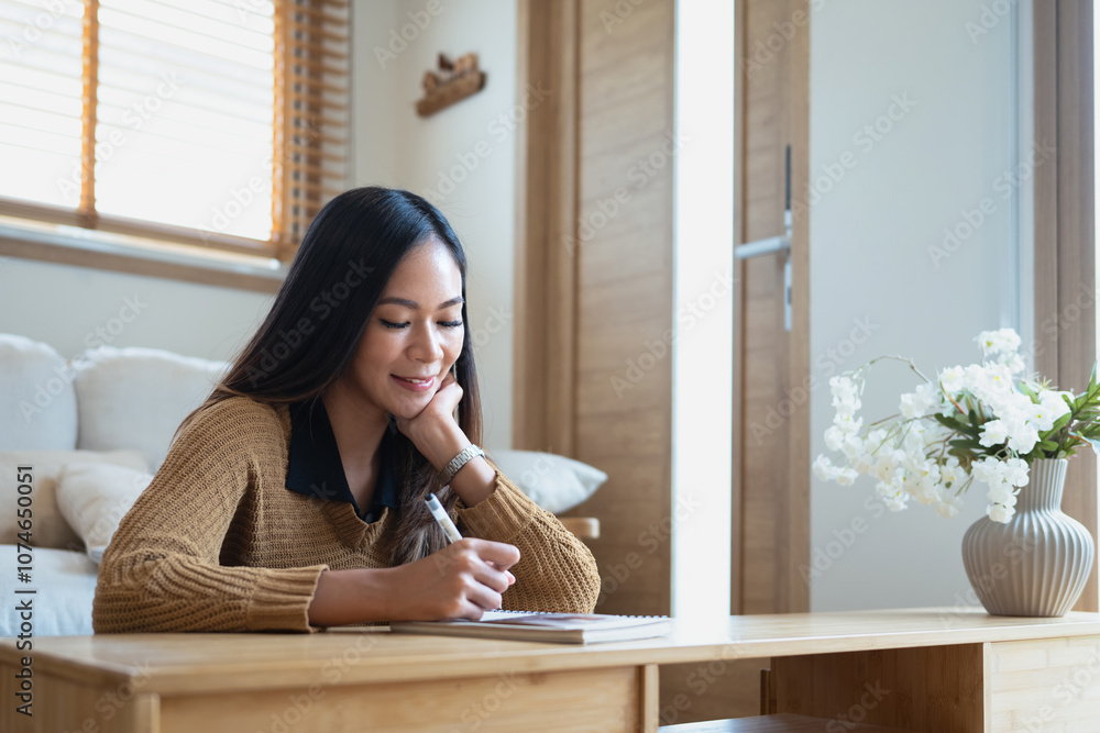 Attractive young woman taking notes with a smile in minimalist room Attractive young woman taking notes with a smile in minimalist room
