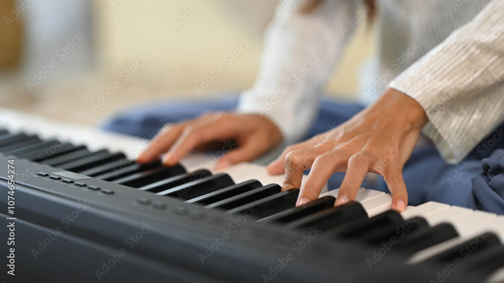 Close up female musician playing an electronic piano in living room Close up female musician playing an electronic piano in living room