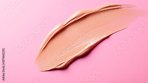 A swatch of foundation on a pink background.