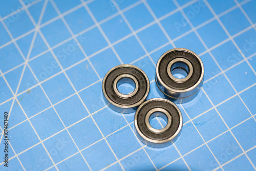 Three 608 RS Ball Bearings - Bearing Steel and Double  Deep Groove Ball Bearings on a blue cutting mat