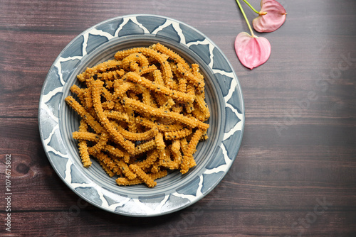 Crunchy fried homemade Chakli sticks with sesame seeds. Chakli is a savory snack from India made out of rice, mixed yellow and green lentils along with spices. Mostly eaten during Diwali festival photo