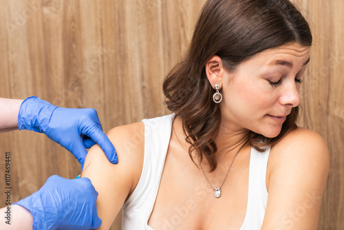 Woman turning away as a medical assistant injecting a vaccine photo