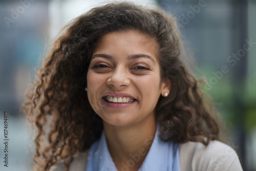 Cheerful girl standing at modern office looking at camera