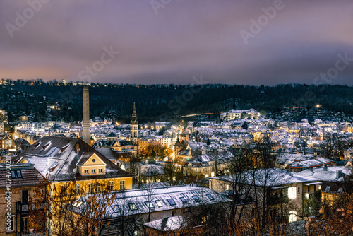 Blick über eine verschneite Altstadt - Stuttgart West - auf den Talkessel. Schnee auf Dächer. Beleuchtete Fenster und Straßen. photo