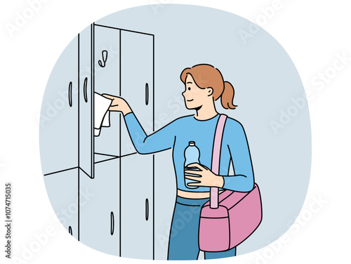 Woman visitor to gym stands near lockers for personal belongings and prepares for sports workout. Girl with bag for sportswear and bottle of water visits gym to maintain good figure
