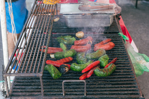 Grilled green chorizo and sausages in a rustic fire pit.