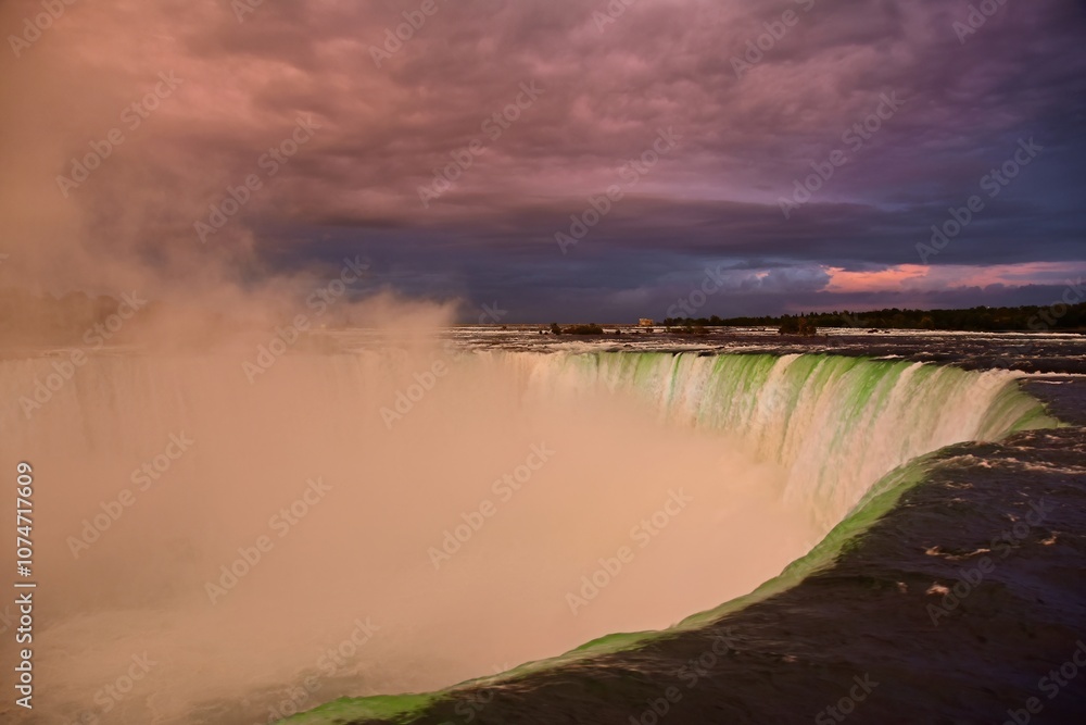 spectacular view of the green- colored illuminatation of horseshoe falls at sunset from the canadian side of the niagara falls in the niagara river, ontario spectacular view of the green- colored illuminatation of horseshoe falls at sunset from the canadian side of the niagara falls in the niagara river, ontario