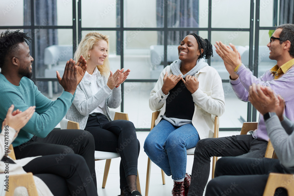 Selective focus of young businesswoman applauding together with interracial colleagues during seminar