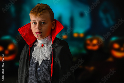 Child dressed as a vampire posing in front of a blurred background with pumpkins and dark trees photo