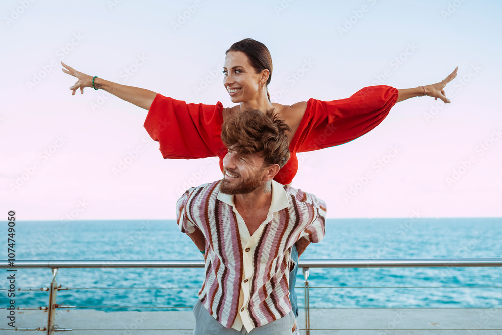 Carefree couple having fun with a piggyback ride by the sea, woman ...