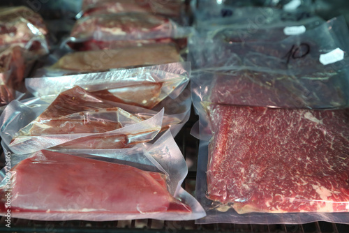 Beef steaks are kept in a special refrigerator before being cooked. Steaks in airtight packaging in the refrigerator. Maturing steaks before cooking. Beef steaks in refrigerator.