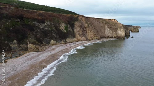 Panning aerial of dramatic cliffs and beach at Shippersea Bay - County Durham, UK photo