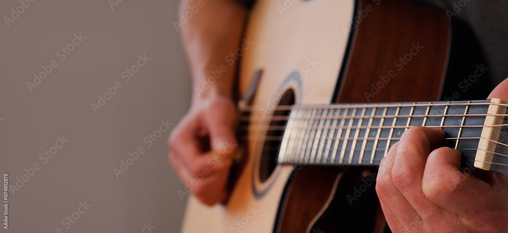 Fototapeta premium Hands playing acoustic guitar. Guitar music as form of self-expression creating personal and unique sound. solo guitarist plays at home capturing essence of relaxation and creativity. Banner