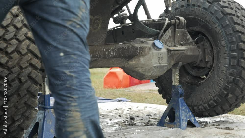 man preparing his car by fixing his tires before getting into the race man preparing his car by fixing his tires before getting into the race