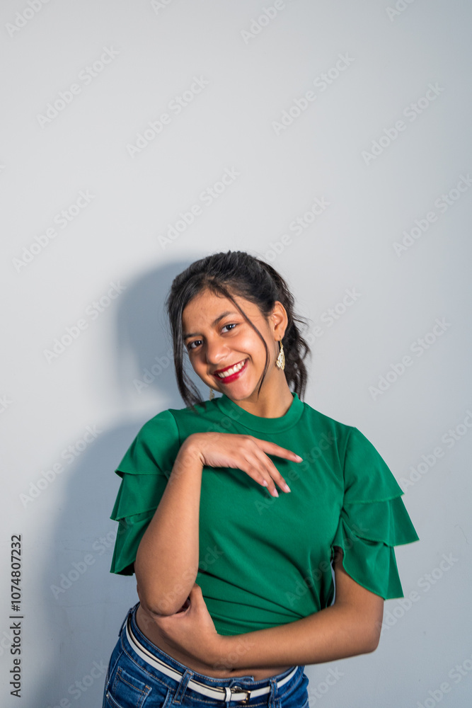A teen in a green shirt is smiling and pointing to the camera A teen in a green shirt is smiling and pointing to the camera