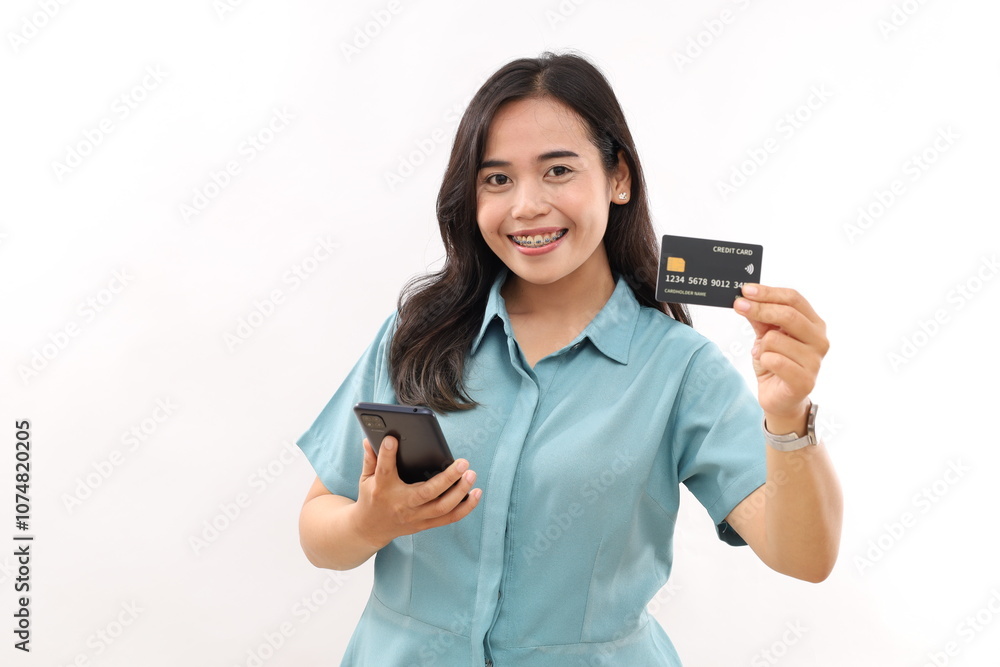 Joyful asian girl smiling, showing credit card and smartphone, recommending mobile phone banking, standing against white background Joyful asian girl smiling, showing credit card and smartphone, recommending mobile phone banking, standing against white background